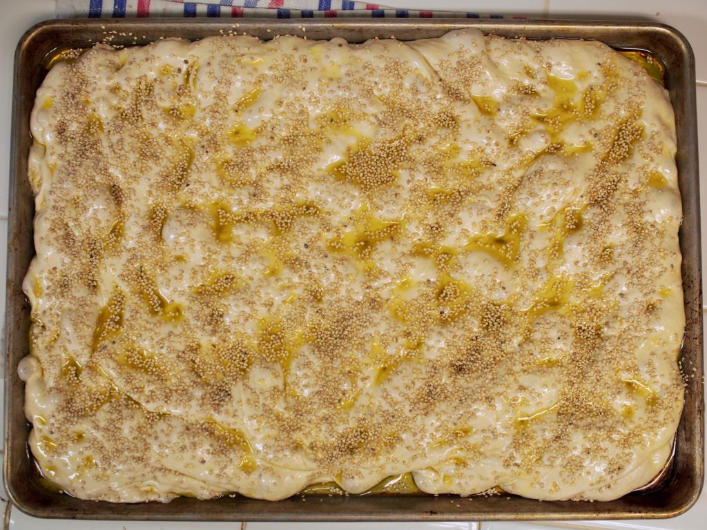 Uncooked focaccia dough in the pan again, seen from directly above.